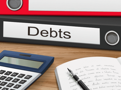 Binder labeled "Debts" with pen and calculator in front of it