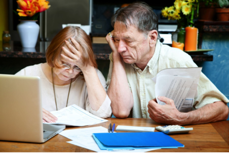 Elderly couple looking over bills