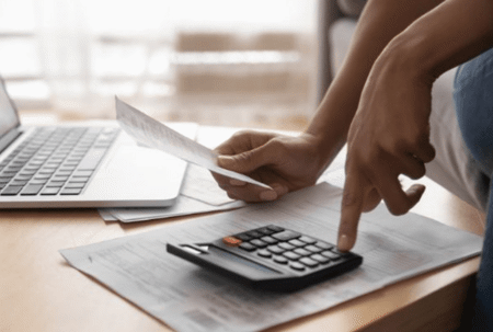 close up of hands using calculator