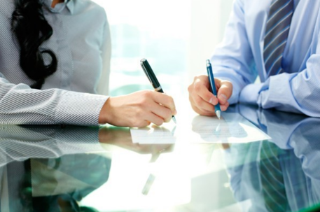 two people signing document