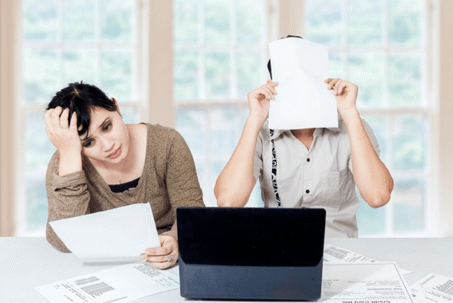 man and woman shrugging over desk with documents