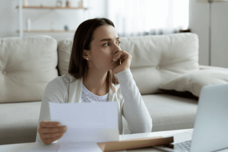 woman holding document and rested head on hand