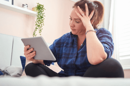 woman holding head on tablet