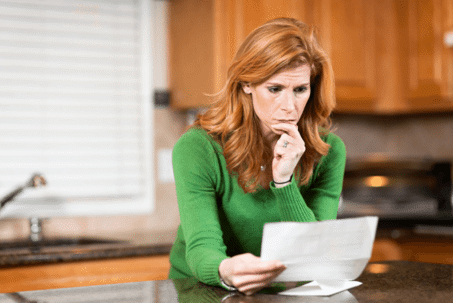 woman leaning over kitchen counter reading document