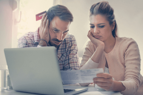 man and woman stressed looking at documents with laptop