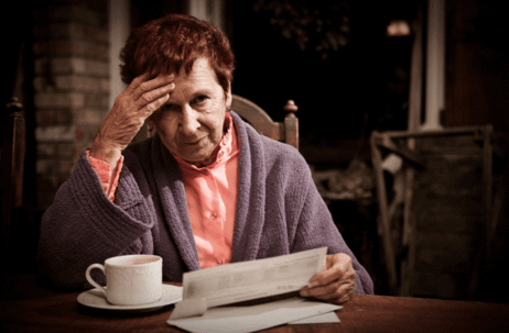 older woman with coffee and document