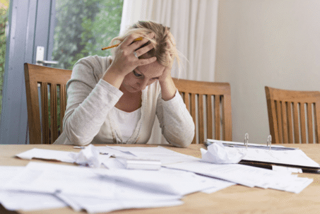 woman stressed holding head at dining table