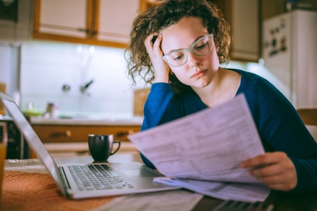 Woman going through bills, looking worried