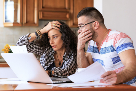man and woman stressed holding documents with laptop