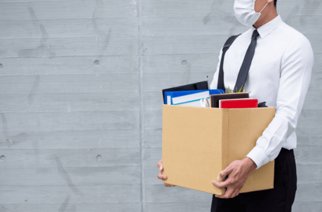 man with desk items in box earing mask