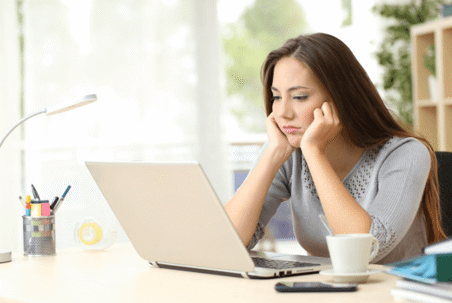 woman shrugging over laptop
