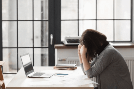 woman with head down at desk