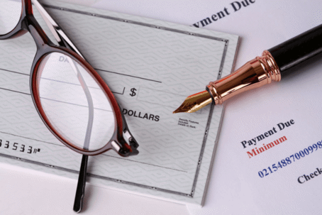 glasses and pen on a check