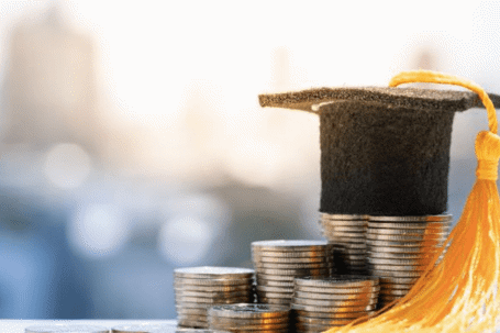 stacked coins and graduation cap