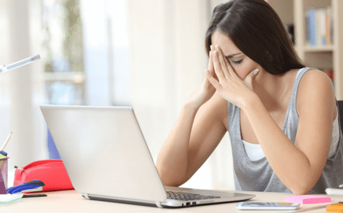 woman stressed holding face over laptop
