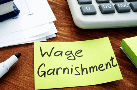 sticky note on desk that reads "wage garnishments"