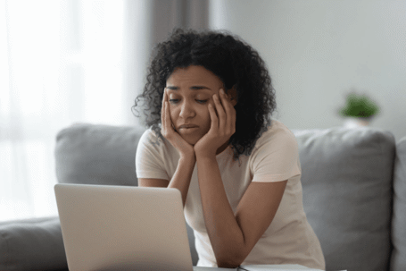 woman shrugging over laptop