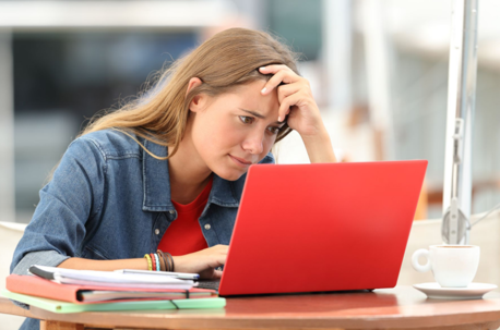 young woman stressed looking at laptop