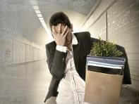 Man walking out of office with personal belongings in a cardboard box