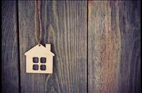 Wood cut out of a house on top of wood paneling