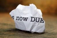 Crumpled paper with "now due" written on it