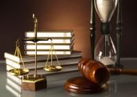 Scales of justice, gavel, stack of books, and sand timer
