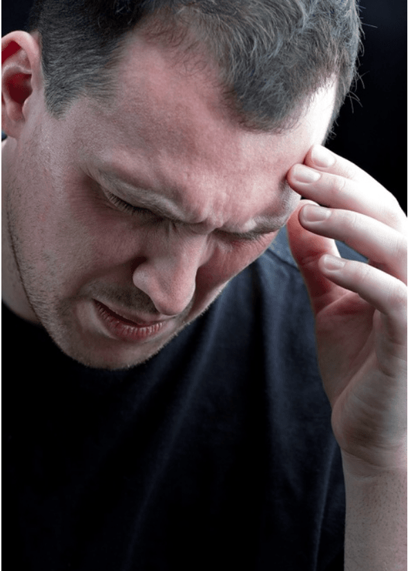 Man with eyes closed and hand at his forehead