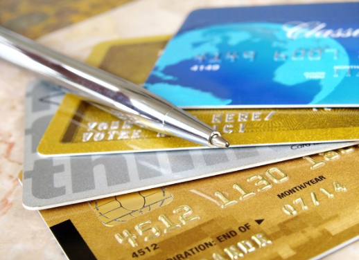 Credit cards fanned out with silver pen set on top
