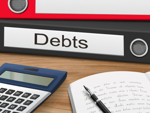 Binder labeled "Debts" with pen and calculator in front of it