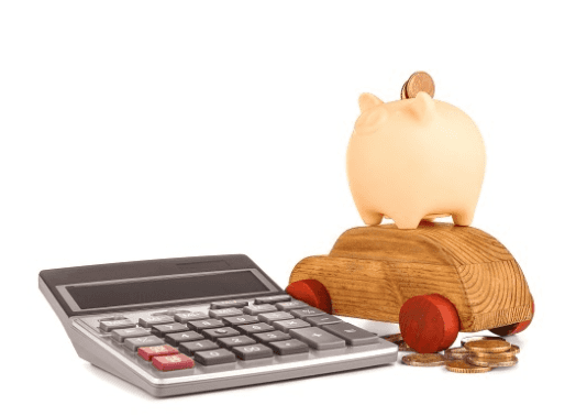 A calculator, piggy bank, wooden toy car, and coins