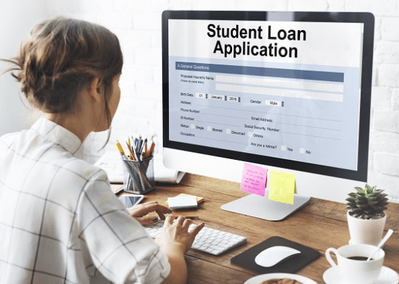 Woman looking at a computer monitor with a student loan application on it