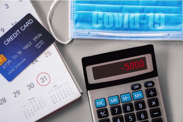 Calculator, credit card, calendar, and medical mask set on counter