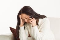 Woman leaning into one hand while her other hand is holding a cell phone to her ear