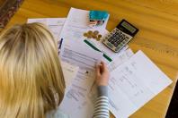 Woman reviewing bills with a calculator