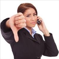 Woman in suit with a phone to one ear and thumbsdown